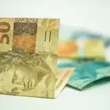 Brazilian Real banknotes in focus with 50 denomination displayed prominently.