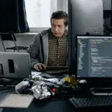 A programmer in a modern office working on computer code, showcasing a focused work environment.