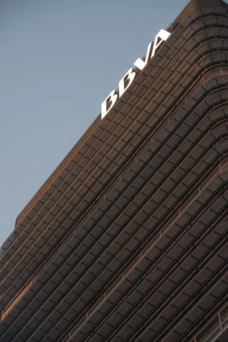 A striking view of the BBVA Tower in Madrid, España, capturing the architectural details at sunset.