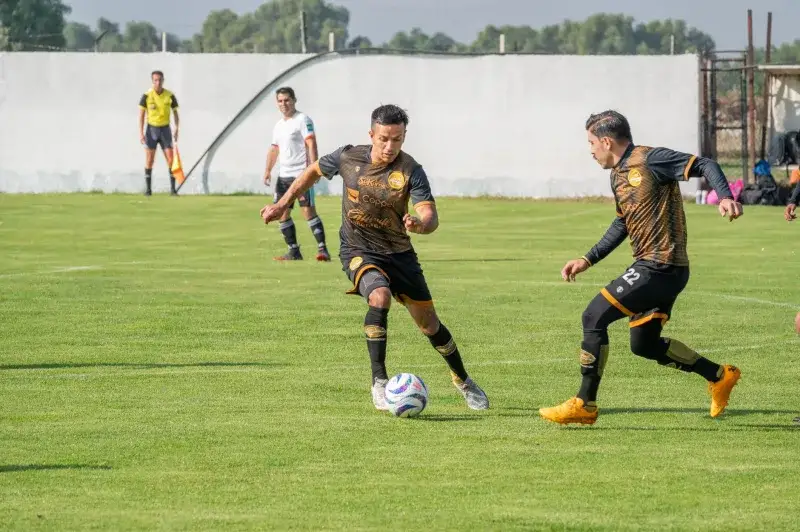 Soccer players in action during a daytime match, displaying teamwork and strategy.