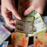 Closeup of hands counting Argentinian pesos in Buenos Aires, Argentina.