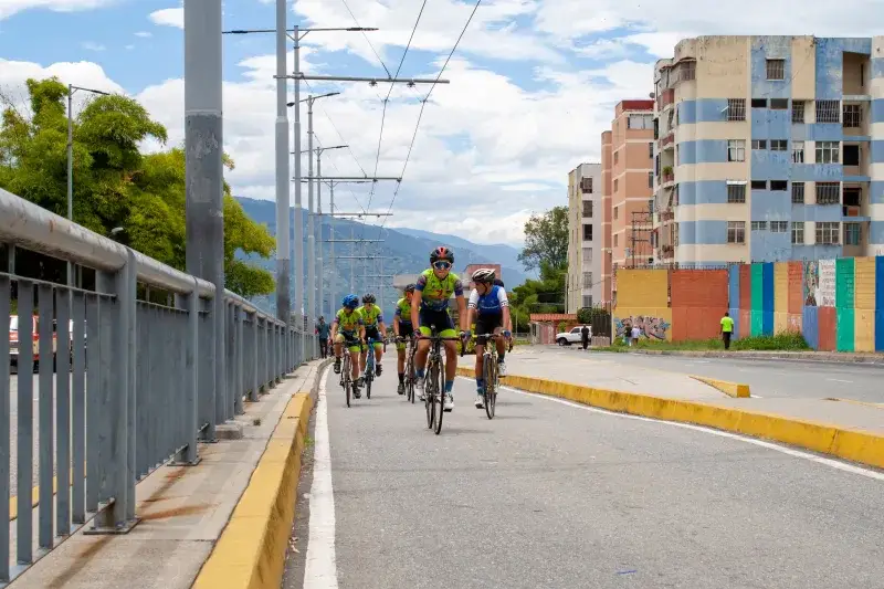 Cyclists riding on a city street in Mérida, Venezuela, showcasing vibrant urban life.