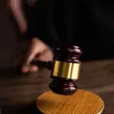 Close-up of a judge's gavel on a wooden block, symbolizing justice and law.