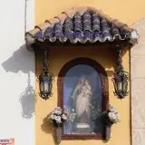 This image shows the Virgen del Carmen statue in El Puerto de Santa María, framed by traditional Spanish architecture.