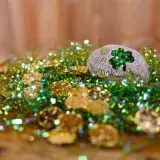 Vibrant St. Patrick's Day decor featuring gold coins and shamrock embellishments on a wooden table.