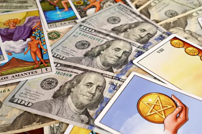 Combination of tarot cards and U.S. dollar bills symbolizing financial prosperity and mysticism.