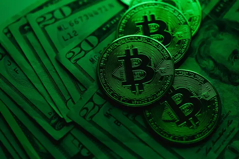 Close-up of Bitcoin coins on US dollar bills, showcasing cryptocurrency's value.