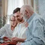 A family cherishing memories by browsing a photo album together indoors.