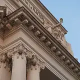 Neoclassical facade of Banco de la Nación Argentina featuring ornate columns and clear blue sky.