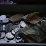 A collection of various coins and banknotes displayed in a tray, showcasing global currency.