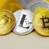Close-up of various cryptocurrency coins including Bitcoin, EOS, and Litecoin on a colorful background.