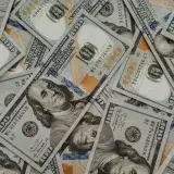 Close-up of American 100 dollar bills scattered, highlighting wealth and currency concepts.