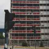 Street view of a high-rise building in Mérida, Venezuela with crosswalk and traffic light.