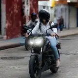 A motorcyclist navigates an urban street in Mérida, Yucatán, Mexico.