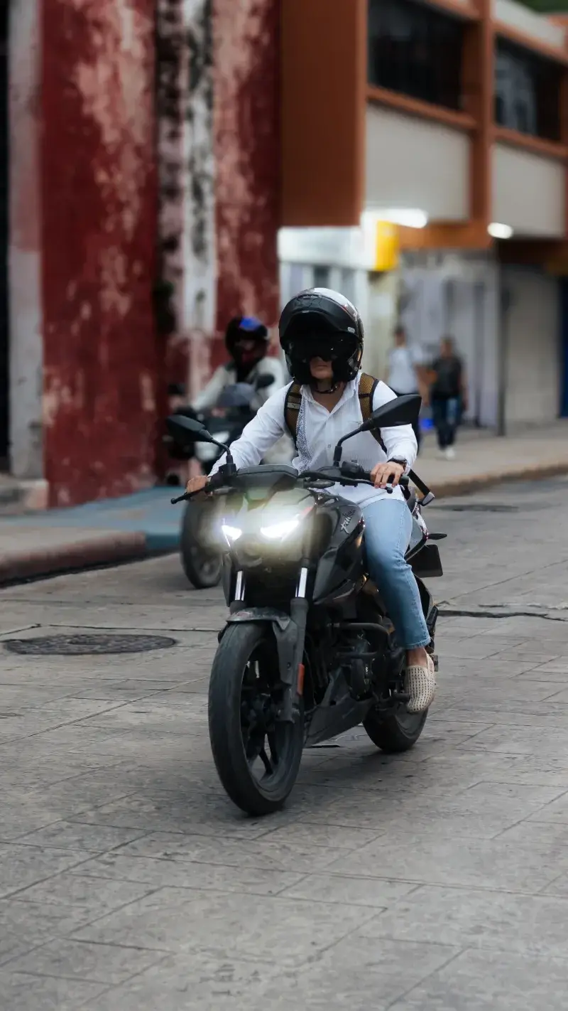 A motorcyclist navigates an urban street in Mérida, Yucatán, Mexico.