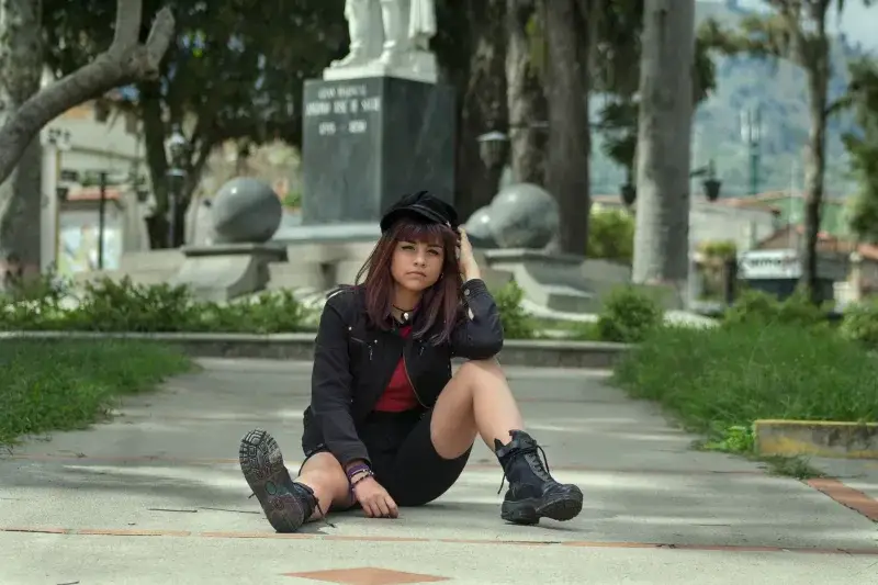 Young woman sitting on pavement in an urban park in Venezuela.