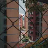 View through chain-link fence of residential district buildings in Mérida, Venezuela.