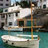 Encantadora barca de madera anclada en el pintoresco puerto de Cala Figuera, Islas Baleares.