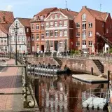 Beautiful canal view with historic buildings in Stade, Lower Saxony, Germany, under a sunny sky.