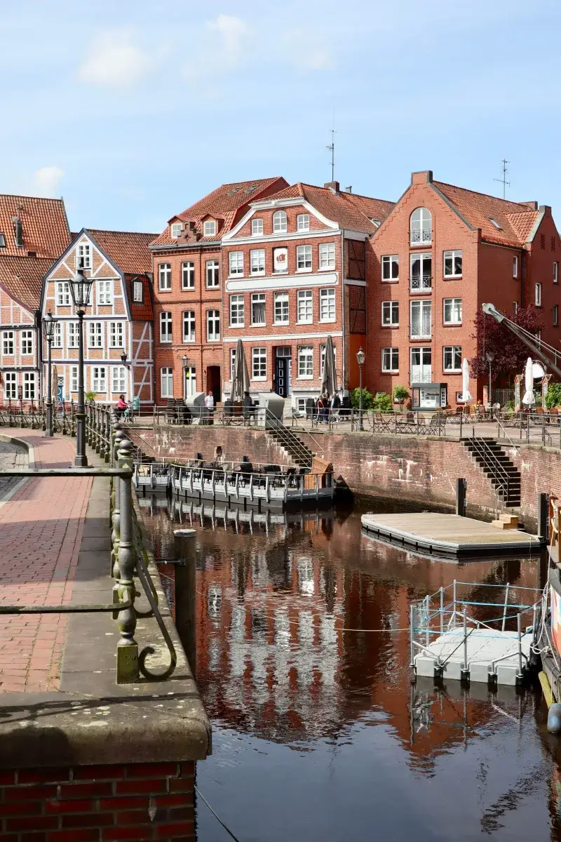 Beautiful canal view with historic buildings in Stade, Lower Saxony, Germany, under a sunny sky.