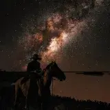 A silhouette of a cowboy riding a horse under the breathtaking Milky Way in Venezuela.