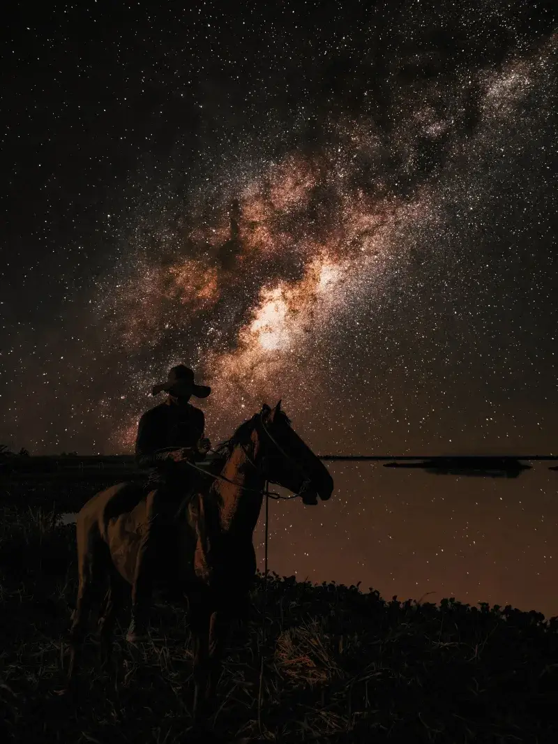 A silhouette of a cowboy riding a horse under the breathtaking Milky Way in Venezuela.
