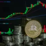 Stacked Bitcoin coins in front of a financial growth graph, symbolizing digital currency investment trends.