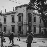 Black and white street scene in Mérida, Venezuela showing pedestrians and historic architecture.