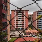 Chain link fence framing modern residential buildings in Mérida, Venezuela.