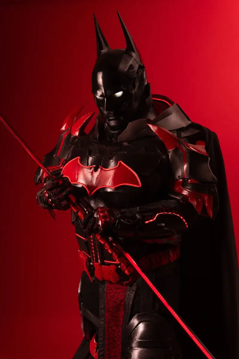Vibrant Batman-inspired samurai cosplay with glowing eyes, set against a striking red backdrop.