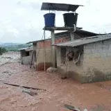 Severe flood damage in Mocoa, Colombia with buildings partially submerged in mudflow.