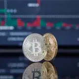 Bitcoin coins with a stock market background representing cryptocurrency and trading.