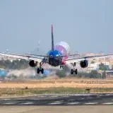 A vibrant airplane lands on the runway at Manises Airport, Valencia, Spain.