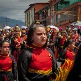 A colorful parade with performers in vibrant costumes in Mérida, Venezuela.