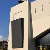 Elegant modern building facade in Nea Filadelfia, Greece under bright blue sky.