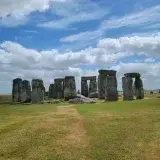Capture of the iconic Stonehenge in England against a backdrop of blue sky and clouds.