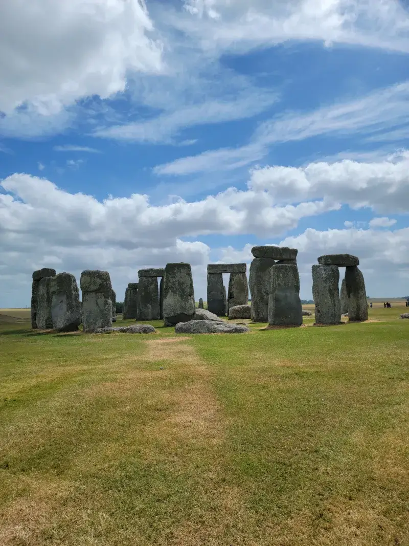 Capture of the iconic Stonehenge in England against a backdrop of blue sky and clouds.