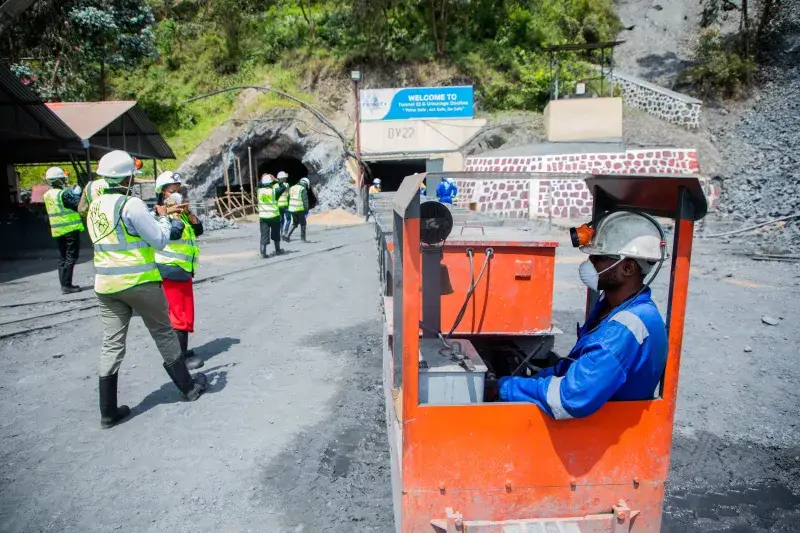 Workers at an outdoor mining site with a focus on rail transport safety.