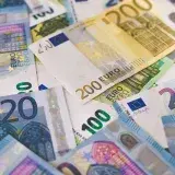 Close-up of various Euro banknotes scattered on a surface, highlighting European currency.