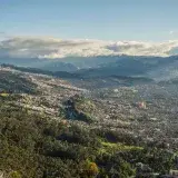 Aerial shot of Bogotá, Colombia, showcasing cityscape and surrounding lush mountains.