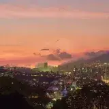 A breathtaking view of Caracas skyline at twilight with a vivid sunset backdrop.