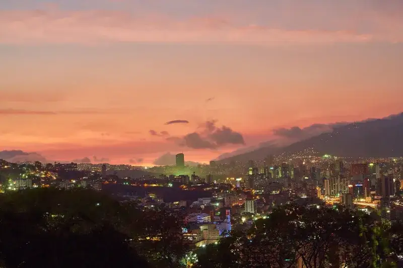A breathtaking view of Caracas skyline at twilight with a vivid sunset backdrop.
