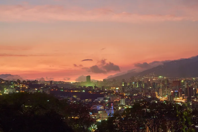 A breathtaking view of Caracas skyline at twilight with a vivid sunset backdrop.