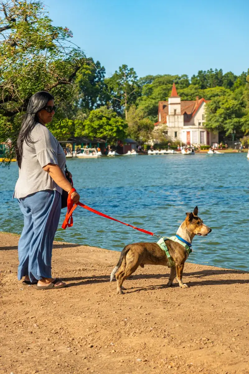 Woman with her dog enjoying a sunny day by Palermo Lake in Buenos Aires, Argentina.