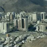 Una dramática vista aérea que captura el horizonte de La Meca, Arabia Saudita, con las montañas circundantes, mostrando la vida urbana y la arquitectura.