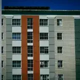 Facade of a modern high-rise building with colorful design against a clear blue sky.