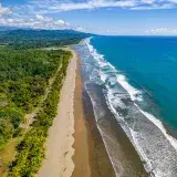 A breathtaking aerial view of the coastline at Puntarenas, Costa Rica, showcasing pristine beaches and lush greenery.