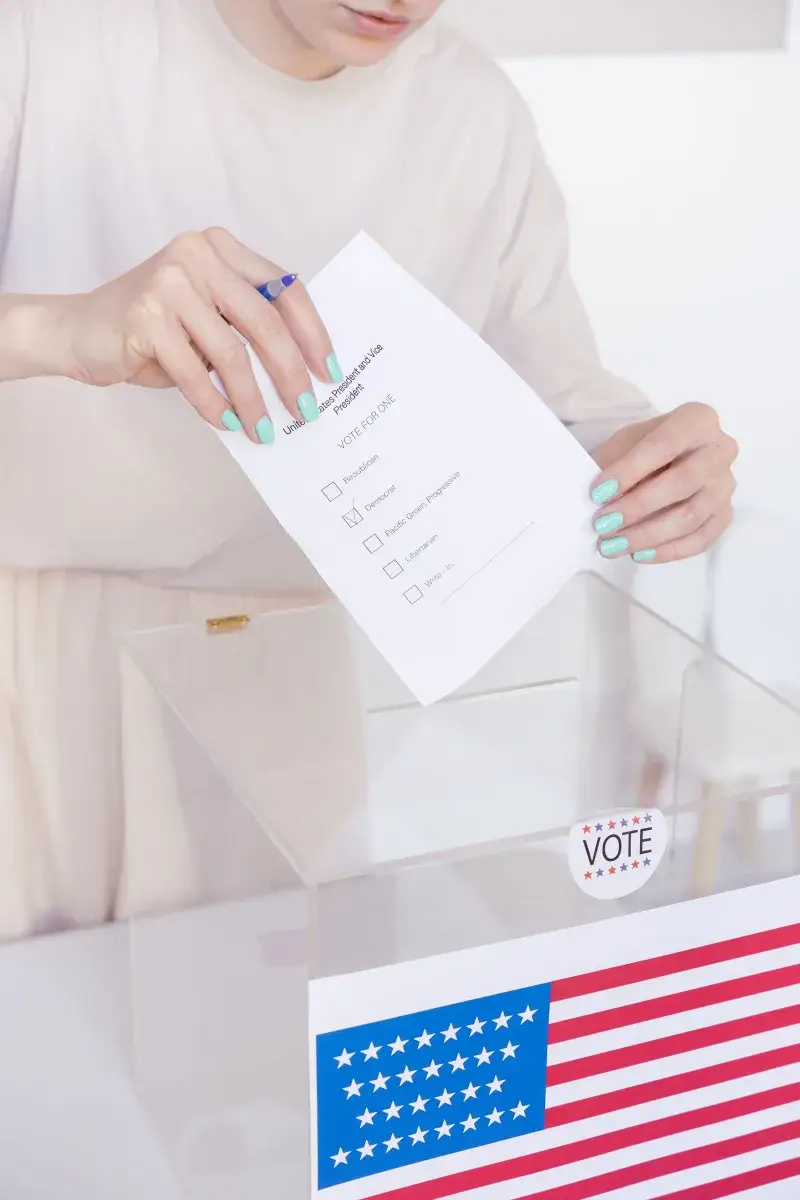 Una persona emitiendo un voto en una urna transparente durante una elección.