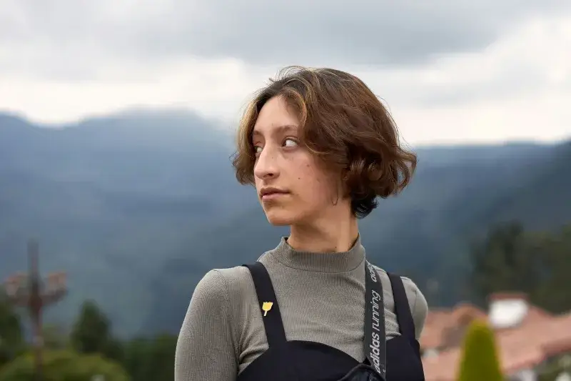 Woman gazes into the distance with scenic mountains in Bogotá, Colombia.