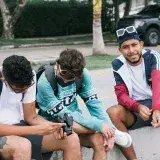Three young men enjoying a casual hangout outdoors in Cartagena, Colombia.